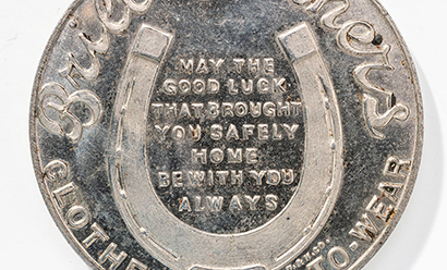 Modern photograph of a silver-colored coin depicting a horseshoe and text in the center