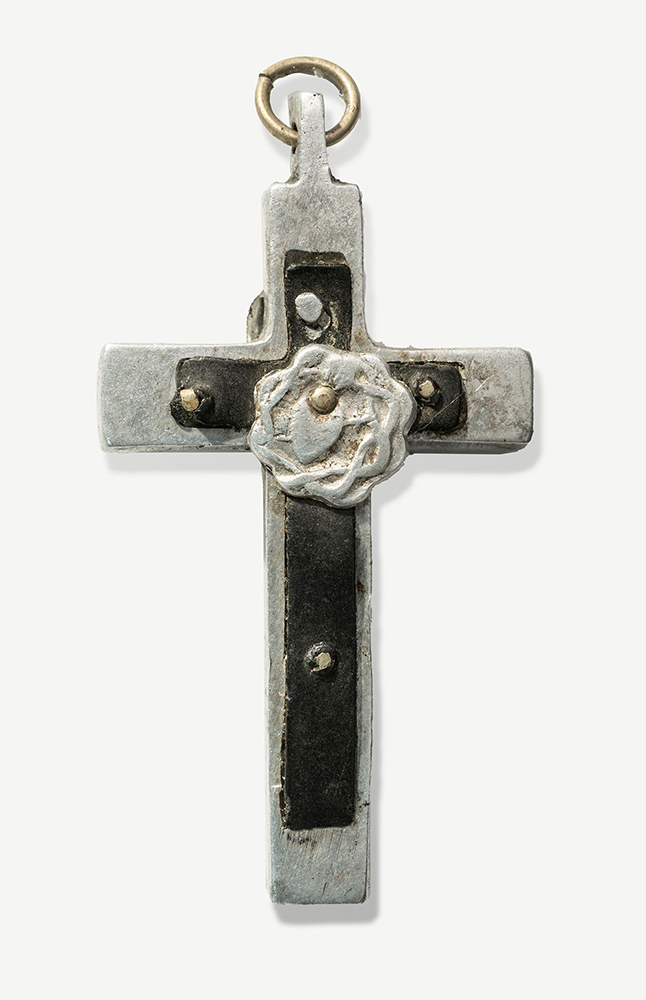 Back of the silver-colored crucifix, featuring a silver-colored rosette or crown of thorns