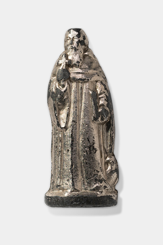 Silver-colored figurine depicting a bearded man in robes