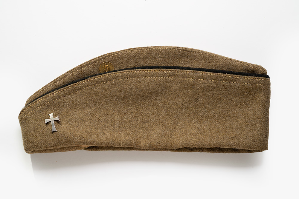 Brown cloth military cap with a cross pin