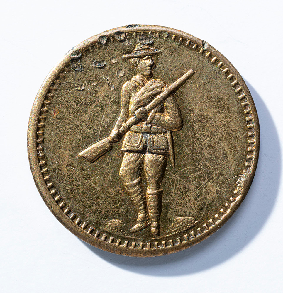 Brass-colored coin engraved with a soldier carrying a rifle