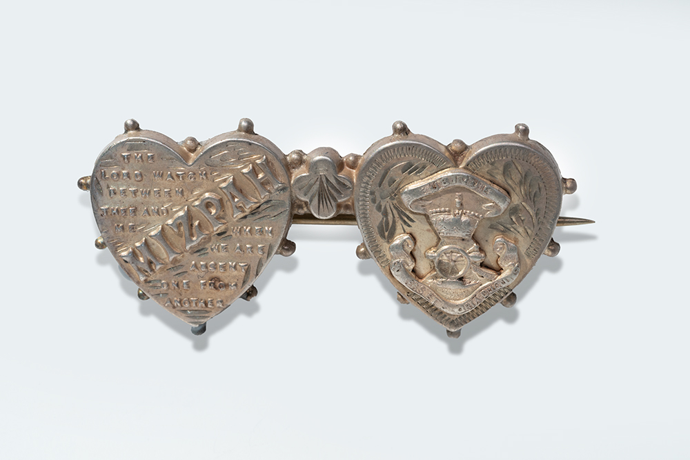 Silvery brooch consisting of two hearts next to each other on a bar