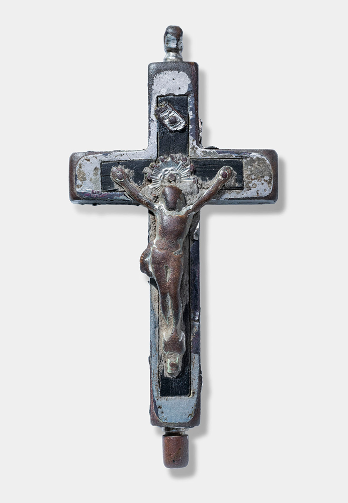 Pewter-colored cross-shaped pendant with a human figure crucified on the front